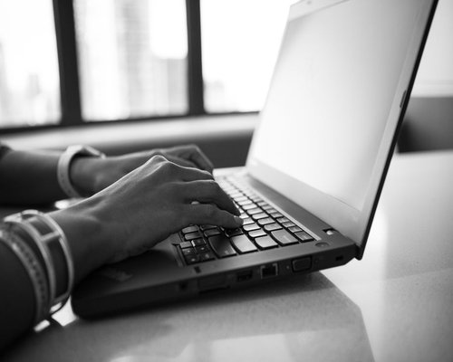 Person typing on laptop in a brightly lit room