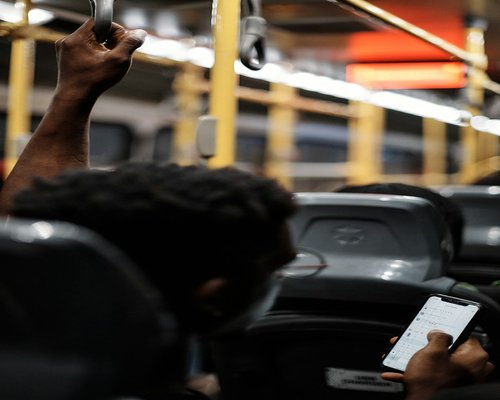 Close up of hands holding a smartphone in public transport